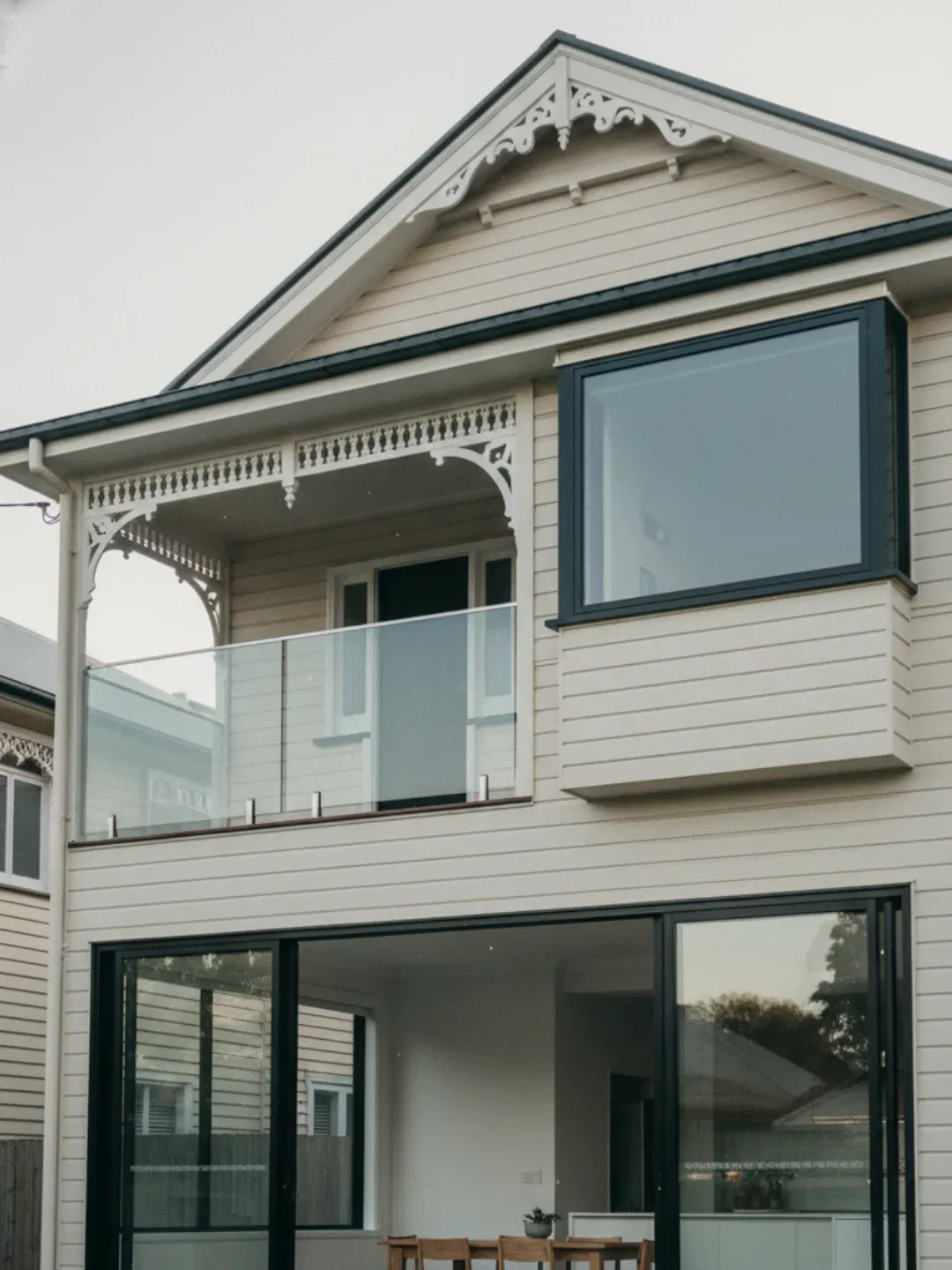 Ascot glazier story with work ute and safely supported glass panel outside a Queenslander home.