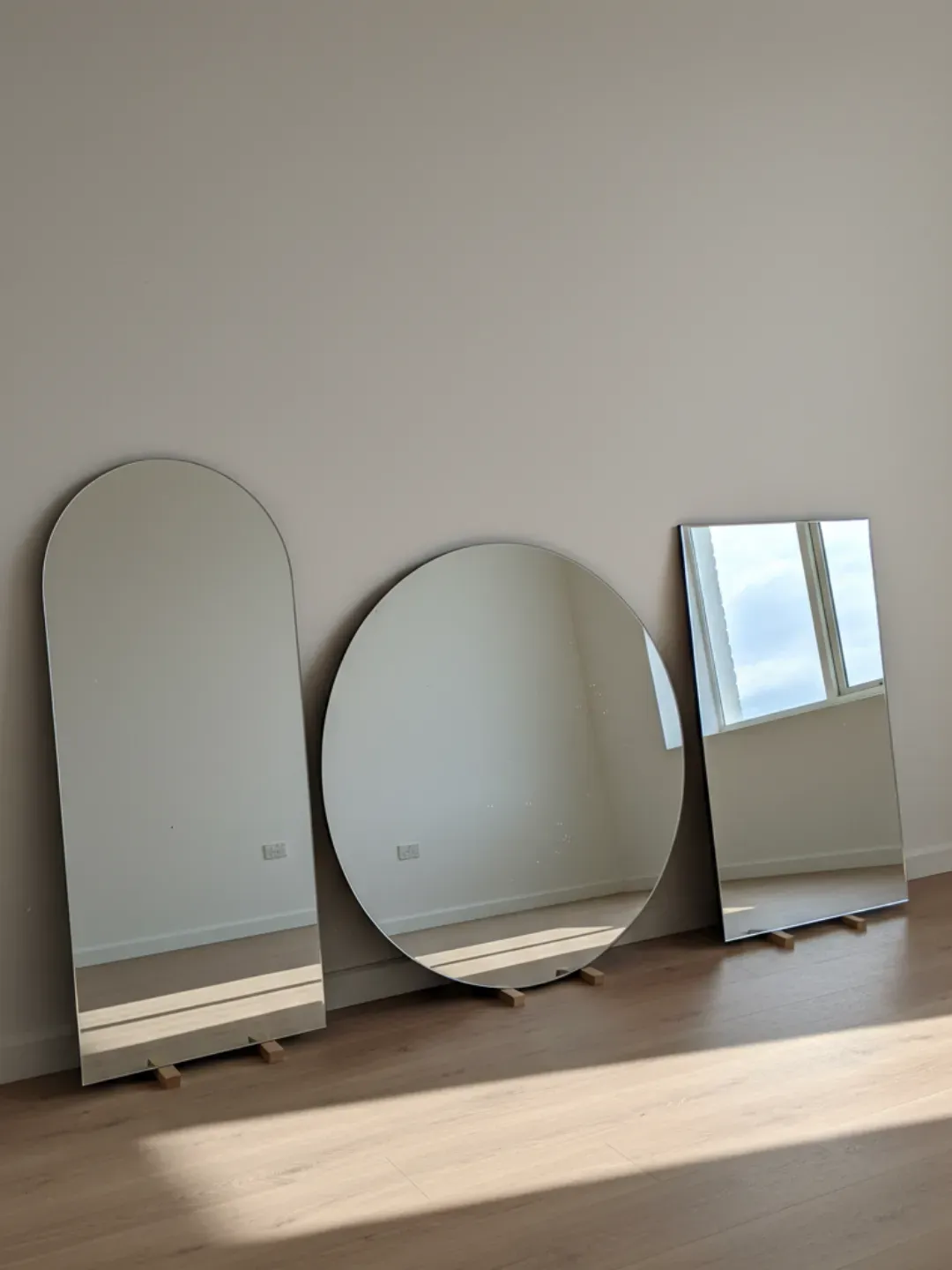 Cut-to-size mirror on padded cutting table with precision tools for Ascot custom fabrication.